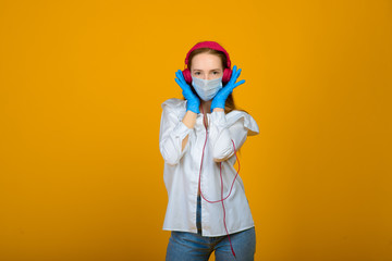 The caucasian girl in blue colored protective face mask. The girl looking at camera. Portrait shot over yellow background. virus and pollution protection concept.