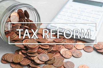 Overturned glass jar with coins and calculator on table, closeup. Tax reform