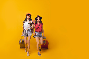 Asian women got tickets to travel promotion on summer, Two young girl traveller holding suitcase...