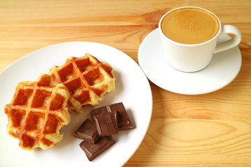 Plate of Belgian Waffles and Dark Chocolate Cubes with Espresso Coffee in the Backdrop	