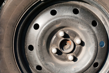 An old car tire wheel without metal cover