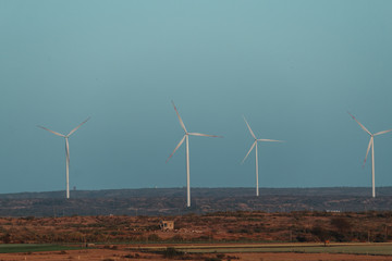 View of the windmills in a wind farm against blue sky at Wankaner, Gujarat, India