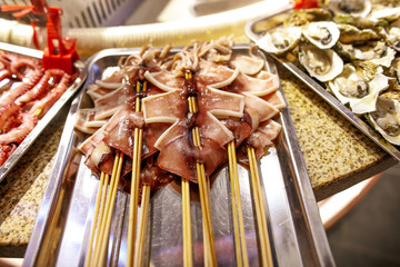 Squid on skewers for frying on the grill.