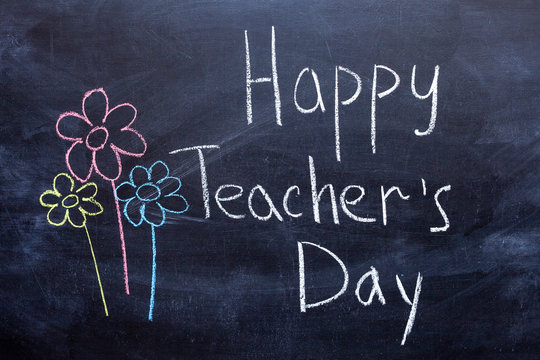 Happy Teachers Day written in chalkboard with white chalk