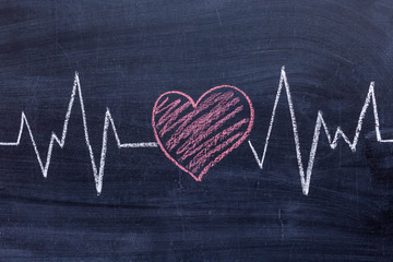 Health concept . Drawing of the heart and pulse diagram on a chalk Board