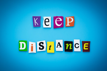 A word writing text - keep distance. Helpful advice, cut letters on a blue background. Headline,...