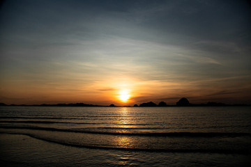 Fototapeta na wymiar Beautiful sunset on the beach with islands