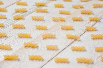 Spiral pasta on a white wooden background. Background for cooking and food.