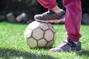 Children play football on the grass, keep their foot on the ball.