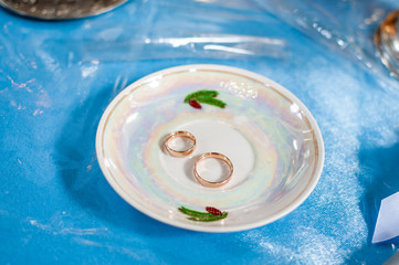 Pair of gold wedding rings on the white plate