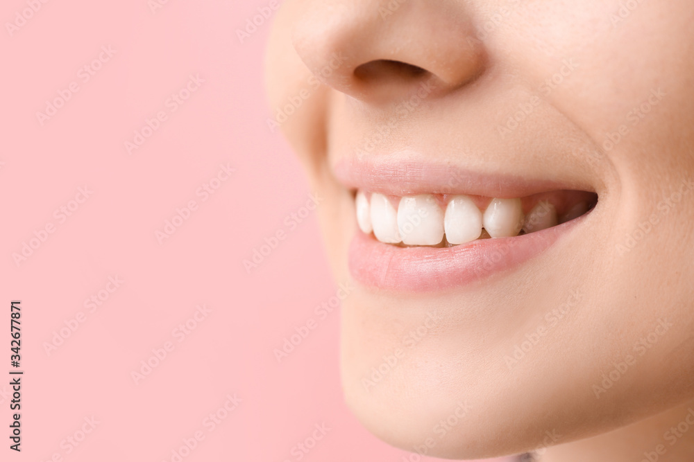 Wall mural young woman with healthy teeth on color background, closeup