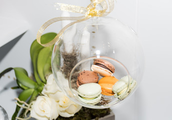Many different colored macaroons in a festive Christmas globe