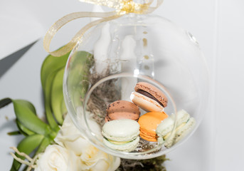 Many different colored macaroons in a festive Christmas globe