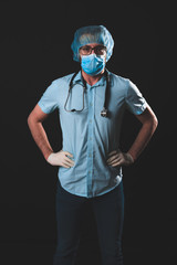 Medical doctor, nurse, surgeon, psychologist working with protective mask, glasses and gloves helping people in the days of panic, pandemic - studio shot on black background.