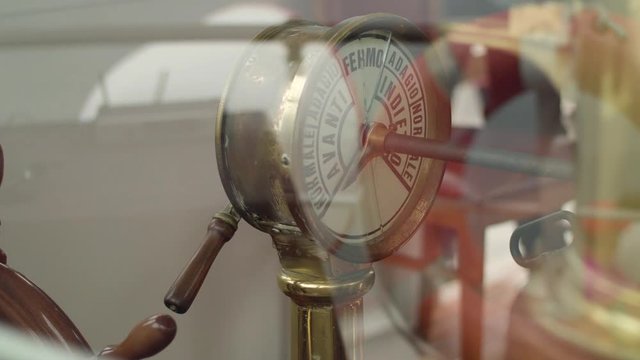Vintage ship engine telegraph on an italian boat. The captain gives the command by moving the handle. Glance through the glass
