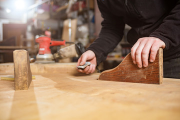 Male carpenter working on old wood in a retro vintage workshop.