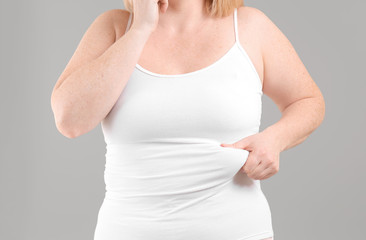 Overweight woman on grey background, closeup