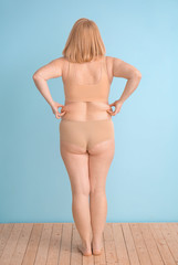 Overweight woman on color background