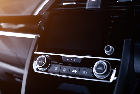 Close up of luxury interior car console with multi functions controls and LCD display.