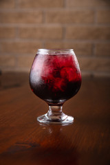 Cocktail in ice bar on blurred wooden background