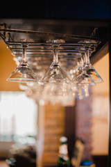 Glass shiny glasses hang on a bar counter with blurry background