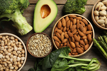 Different products rich in vitamin E on wooden table, flat lay