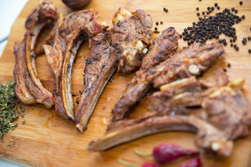 Azeri national antrikot kebab on a wooden board . Dry Satureja . Dried savory spice Satureja hortensis . Copper pepper dish . Antrikot kebabs .