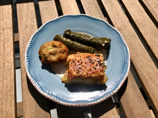 Traditional Turkish Food Stuffed Grape Leaves Dolma, Borek / Burek and Mucver also called Fried Zucchini Balls on Wooden Table.