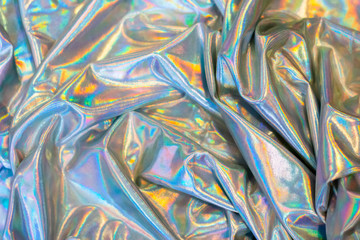 Holographic iridescent mermaid foil texture background. Futuristic neon trendy silver colors