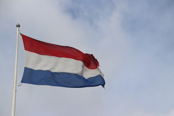 Red white blue flag flutters in the wind as a sign of the country Dutch