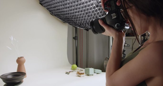 Product photographer taking photos in home studio - side profile