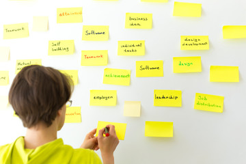 Business people write notes on post paper stickers. Meeting and brainstorming team.
