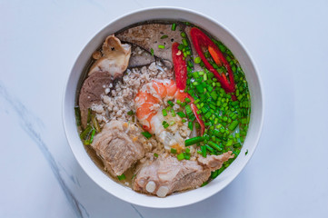 Vietnamese noodle soup. Fresh rice noodle cook. Garnished herb on wood vintage table. Vietnamese...