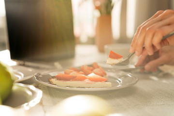 Female eating delicious cheesecake at the morning