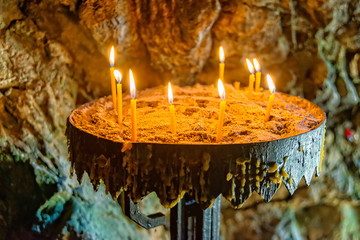 Burning candle in the cave. Candles burning inside mysterious in dark cave in Serbia.