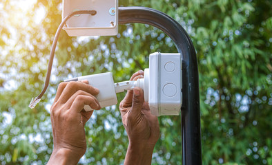Technician installing IP CCTV camera and water proof box to protect camera is home security system...