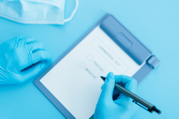 corona virus test result document on blue background with doctor blue gloves and mask