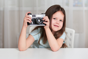 Naklejka premium A little girl with an old camera