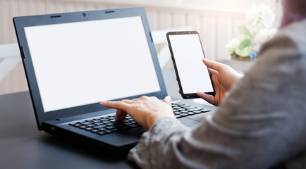 Close-up view of businesswoman searching for information on smartphone and using laptop working at home, Concept work from home