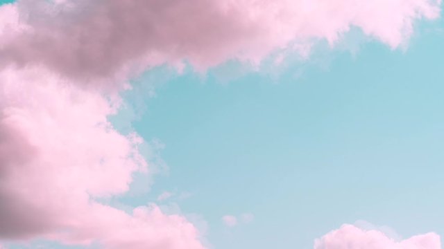 Motions clouds. Puffy fluffy beautiful pink clouds on turquise sky time lapse. Slow moving clouds. Pastel palette. Fantasy paradise concept