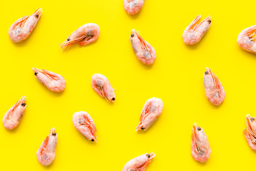 Shrimps - frozen - pattern on yellow background top view