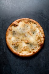 Italian pizza four chesses on black background top