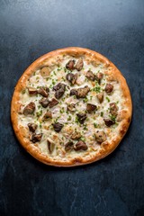 Italian pizza with cheese white mashrooms vegetables on black background top