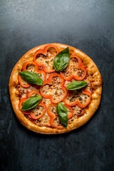 Italian pizza with cheese pepper basil vegetables on black background top