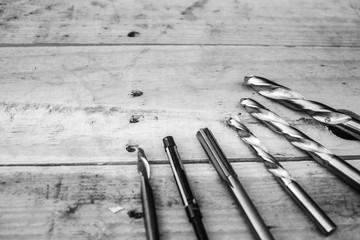 Carbide drills are laid on wood floors in black and white tones.