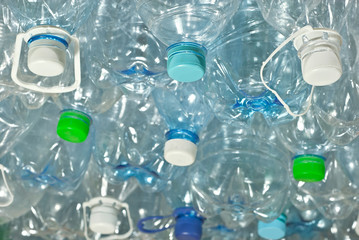 Many plastic bottles are dumped. Texture of transparent bottles of water. Concept of environmental pollution and environmental problems. Dirty plastic closeup.