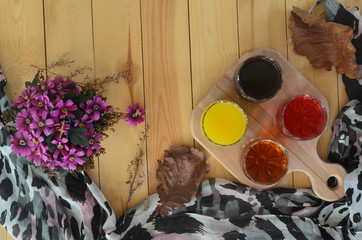 Autumn flat lay. Healthy drinks coffee tea berry and orange juice top view. Handkerchief and dry leaves on a wooden background. Cozy atmosphere . Space for text