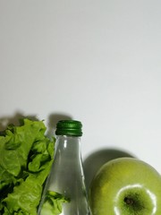 Lettuce leaves, water bottle, Apple as a healthy food concept.