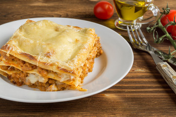 Meat lasagna on a wooden background.