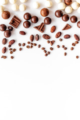 Sweets background with chocolate pralines on white desk top-down frame copy space